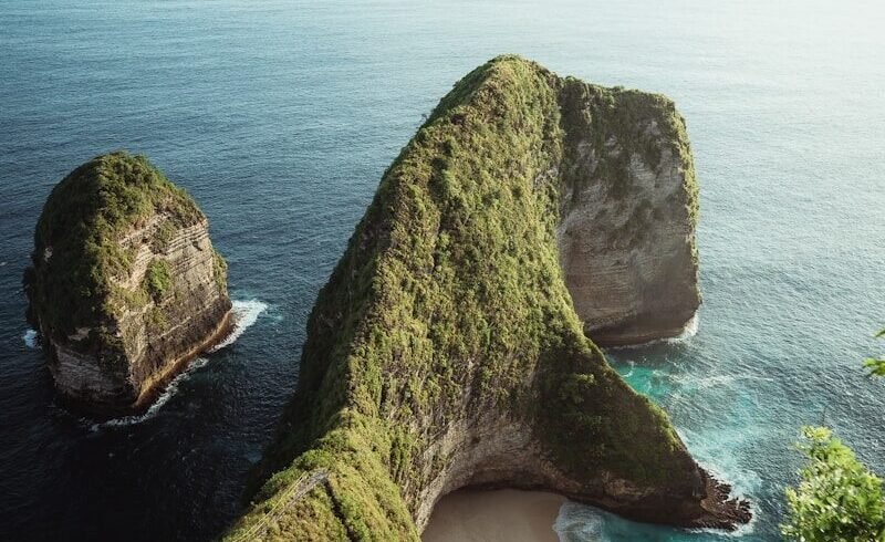 a couple of large rocks sitting on top of a lush green hillside