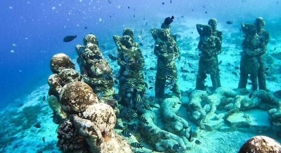 a group of statues sitting on top of a coral reef