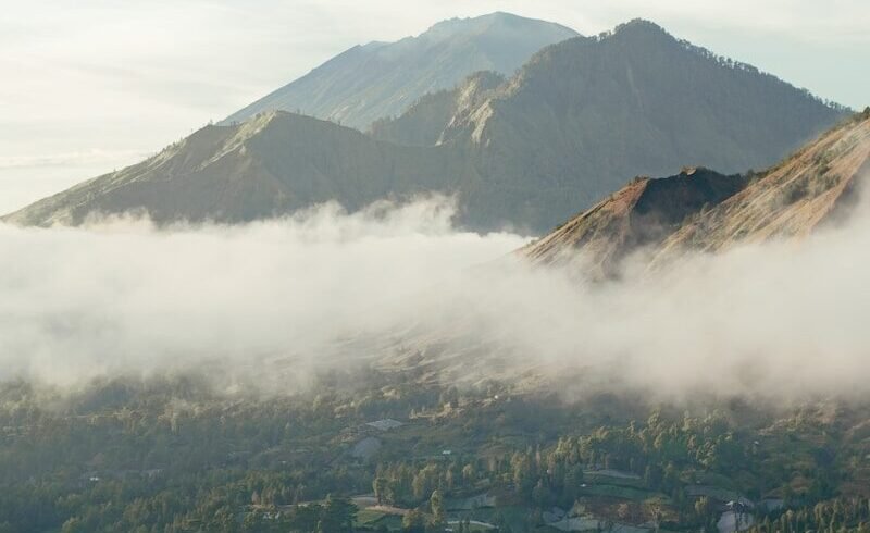 a valley with a town in it and mountains in the back