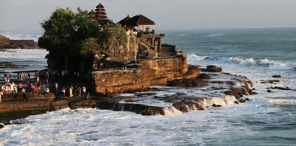 Breathtaking view of Tanah Lot Temple on the rocky coast of Bali, Indonesia, during sunset.