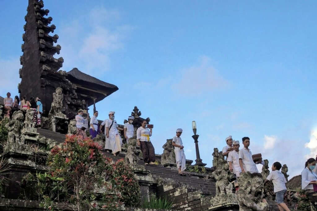 People in traditional attire at the iconic Besakih Temple in Bali, Indonesia, during a cultural ceremony.
