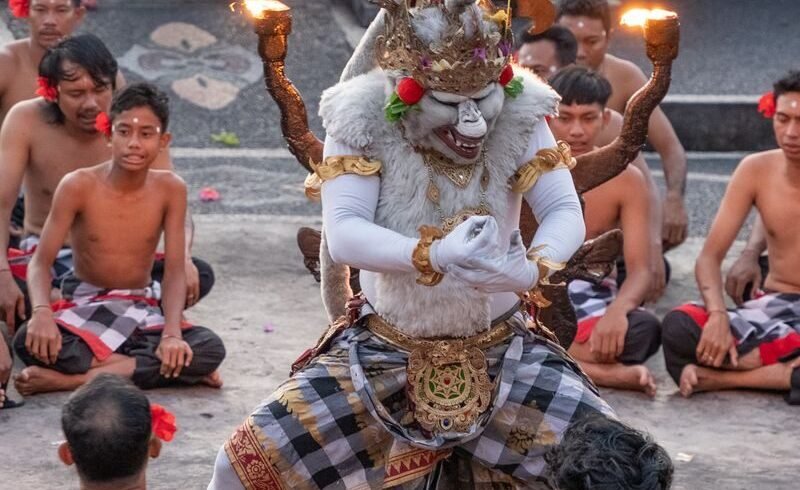 A vibrant traditional Kecak dance performed outdoors in Bali with dancers in cultural attire.