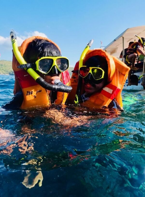 Two children snorkeling near Nusa Penida in Bali with life jackets and snorkel gear.